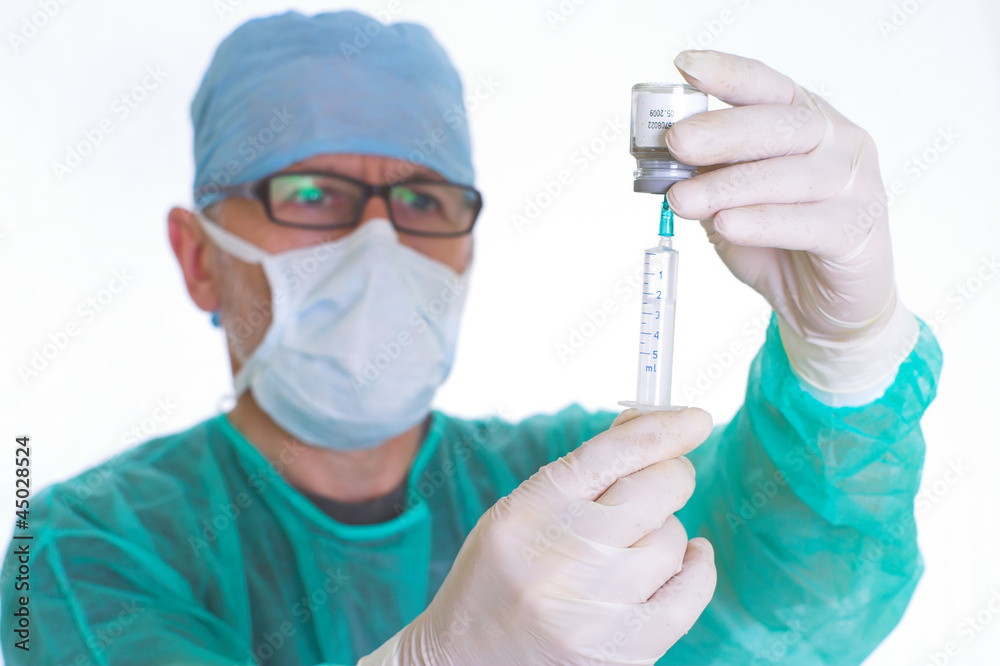 doctor in surgical smock gets ready for  injection