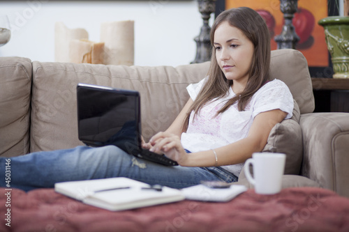 Cute young woman working in her couch