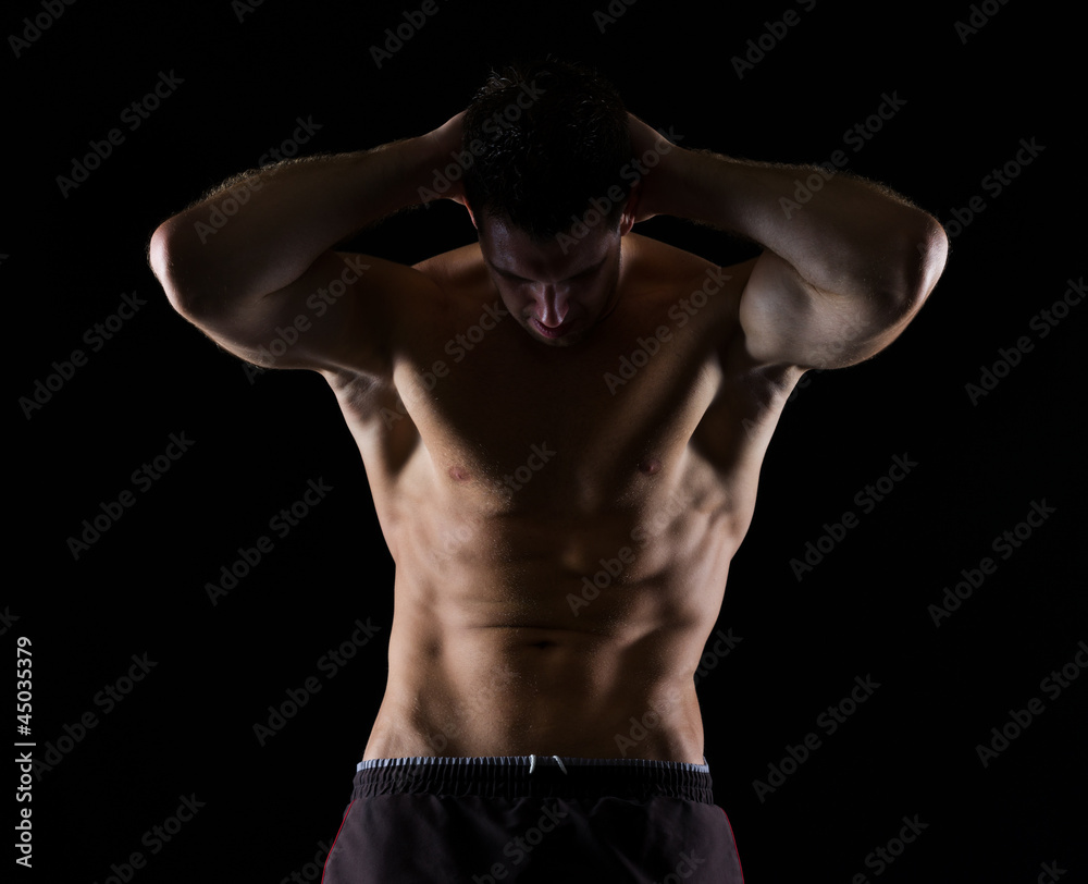 Strong male athlete posing on black Strong male athlete posing on black