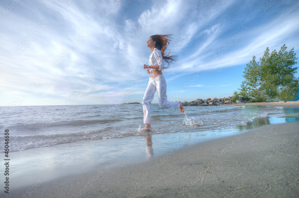 Naklejka premium Sporty woman running in sea coast