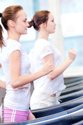 Free Download Two young sporty women run on machine - GFXLoad