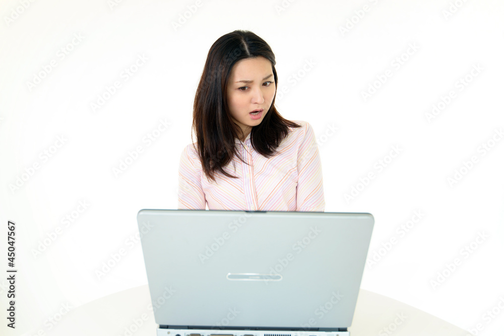 パソコンの画面を見て驚いた表情をしている女性 パソコンの画面を見て驚いた表情をしている女性