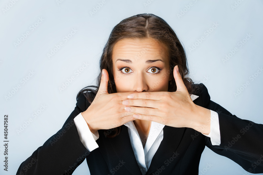 Business woman covering mouth, over blue Business woman covering mouth, over blue
