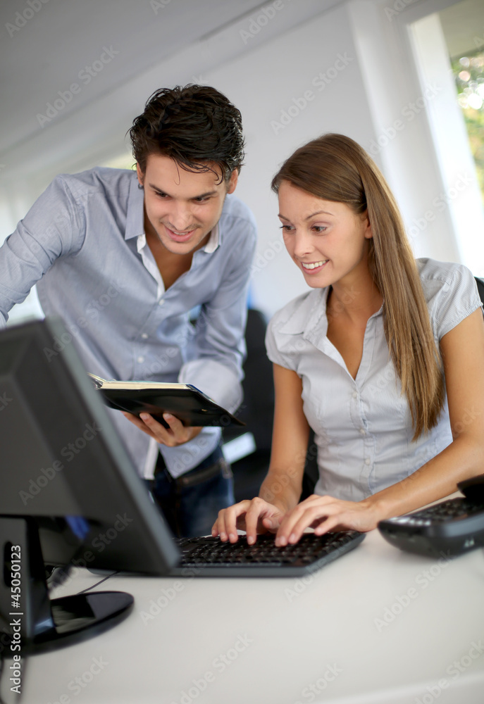 Business partners at work in front of desktop Business partners at work in front of desktop