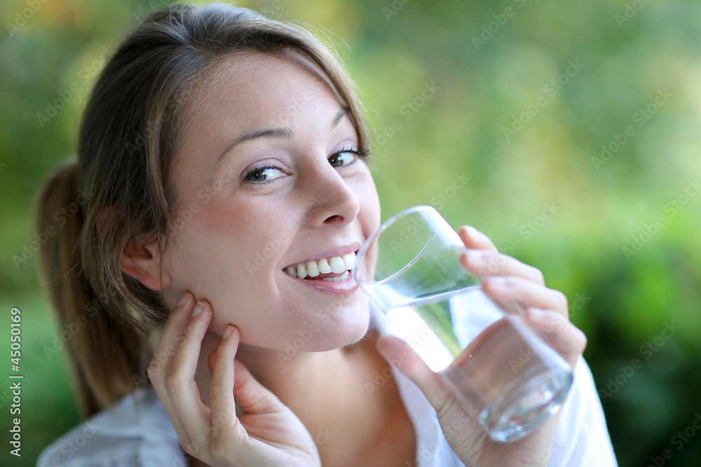 Smiling woman drinking fresh water from glass Smiling woman drinking fresh water from glass