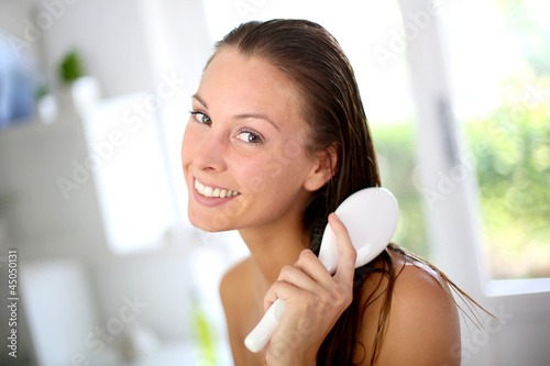 Portrait of smiling girl brushing her hair photo