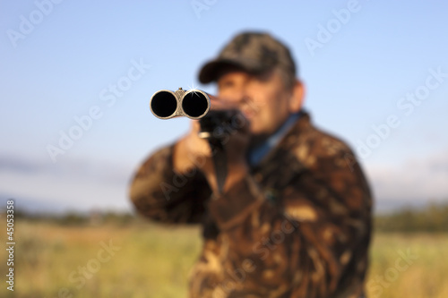 Hunter taking aim with a gun
