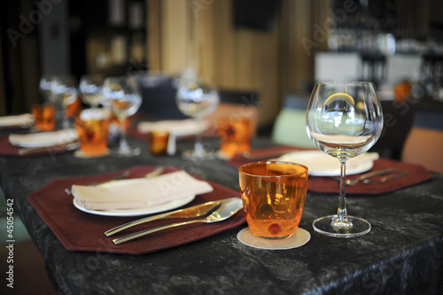 Glasses, Wine Glasses and plates on table in restaurant