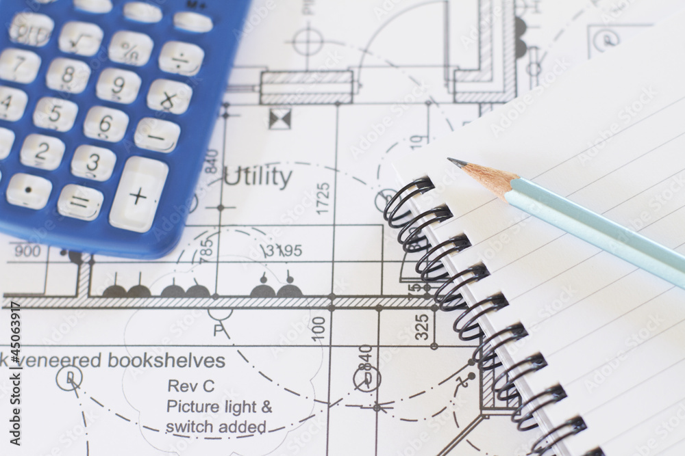 Calculator, Notepad And Pencil Arranged On House Plans Calculator, Notepad And Pencil Arranged On House Plans