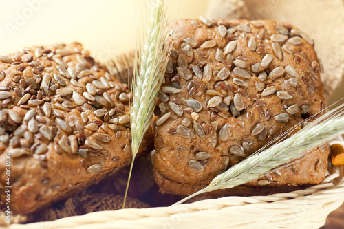 Corn bread in a basket and ears of wheat
