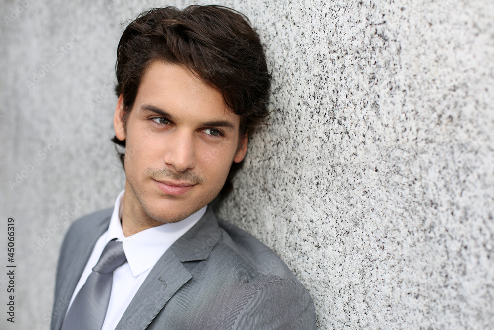 Closeup of handsome businessman leaning on wall Closeup of handsome businessman leaning on wall