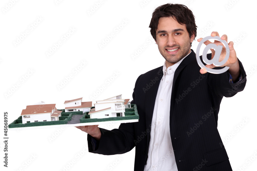 Architect with a model of a housing estate and an @ sign