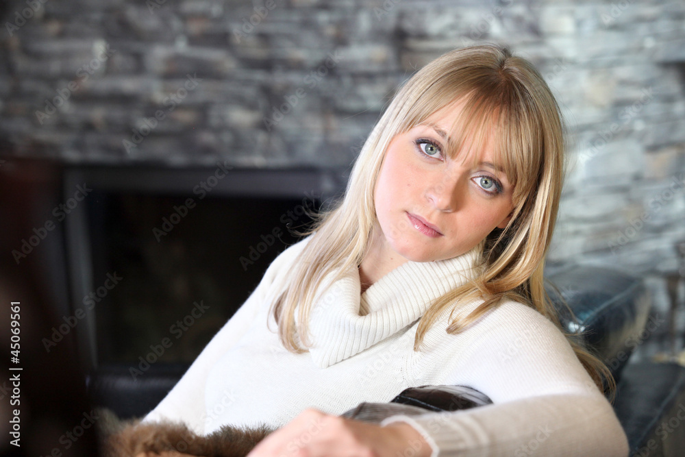 Woman sitting by fireplace Woman sitting by fireplace