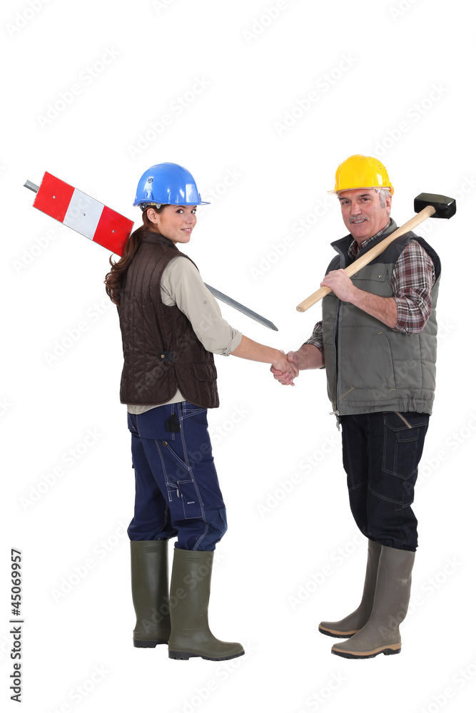 young female apprentice shaking hands with male instructor young female apprentice shaking hands with male instructor