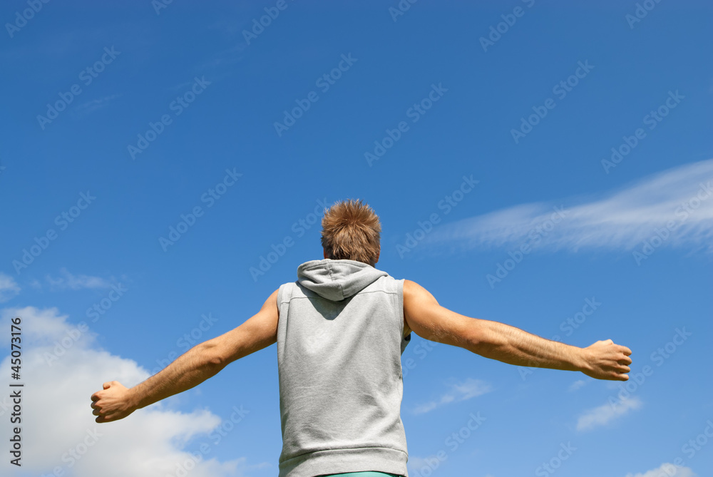 Guy in sports clothing on blue sky background Guy in sports clothing on blue sky background