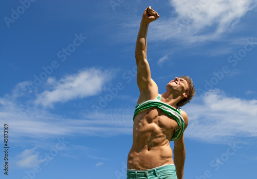 Happy fit man with his arm raised in joy