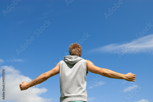 Guy in sports clothing on blue sky background