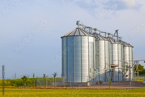 silver silos in corn field