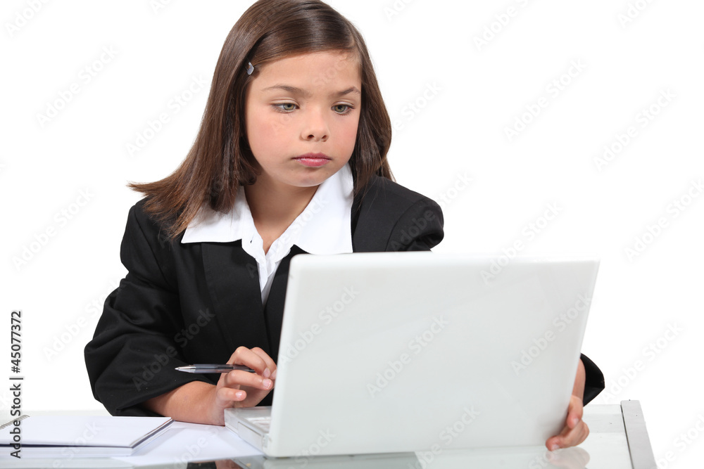 Young girl in a suit working at a laptop Young girl in a suit working at a laptop