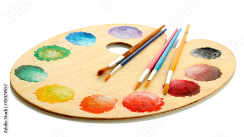 wooden art palette with paint and brushes isolated on white