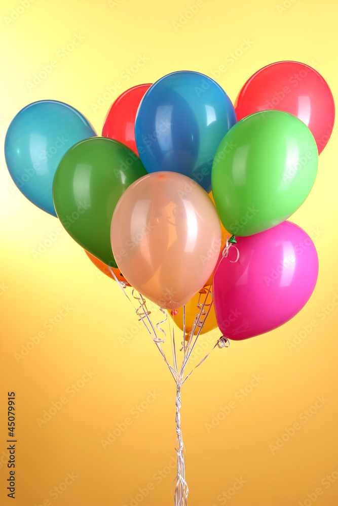 Colorful balloons on yellow background
