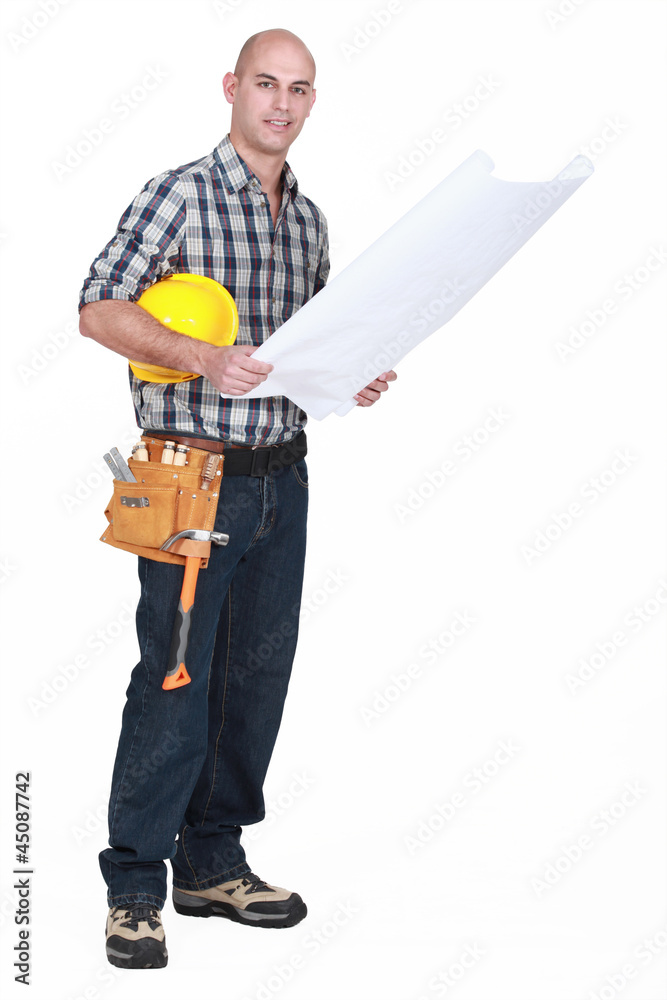 full-length shot of carpenter consulting blueprints full-length shot of carpenter consulting blueprints
