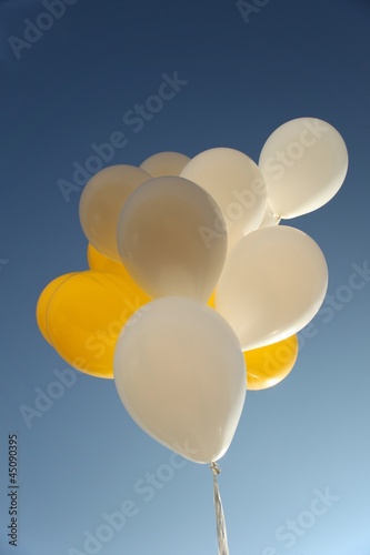 yellow and white balloons and blue sky