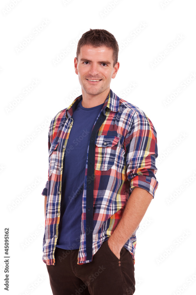 young man smiling with hands in pockets young man smiling with hands in pockets