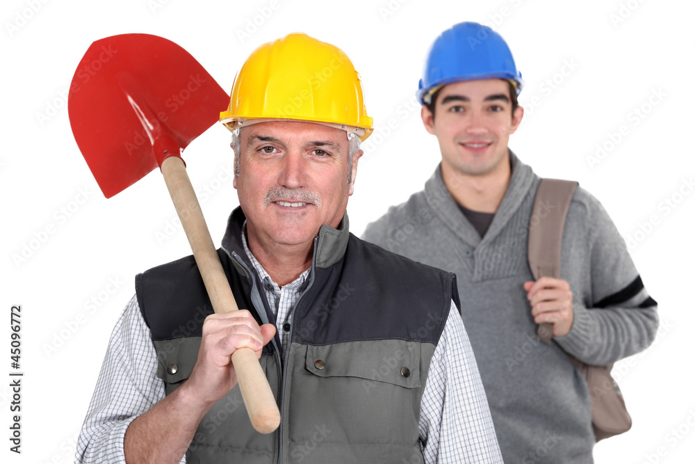 Experienced tradesman standing in front of his apprentice Experienced tradesman standing in front of his apprentice