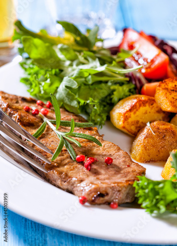 Grilled steak with baked potatoes and salad
