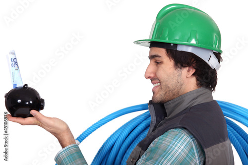 Electrician holding piggy-bank