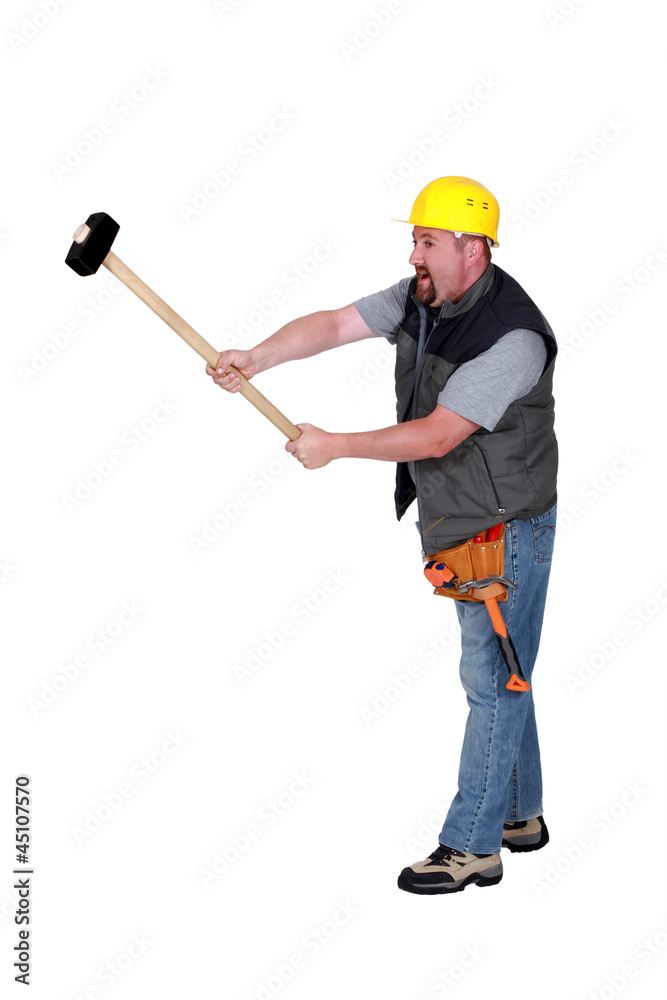 A construction worker with a sledgehammer. A construction worker with a sledgehammer.
