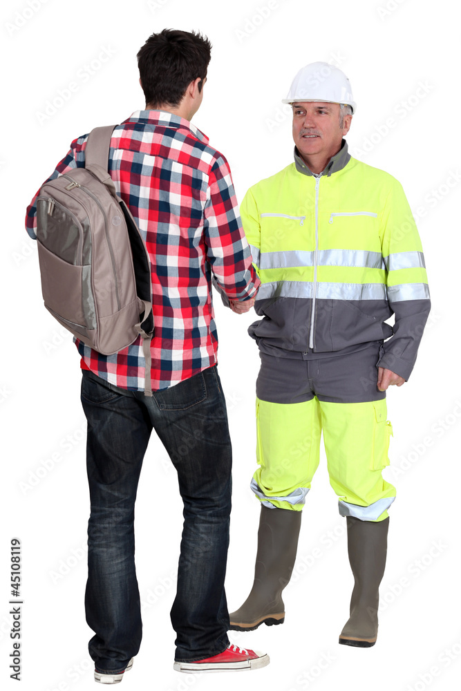 Builder greeting young trainee Builder greeting young trainee