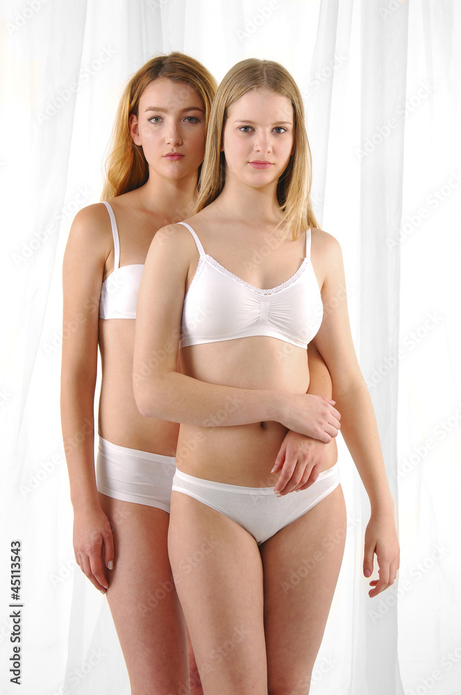 Foto de Portrait of two beautiful young underwear women posing together. do  Stock