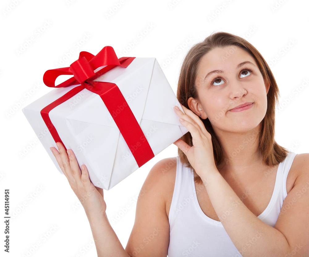 Mädchen schüttelt sanft ein Geschenk Mädchen schüttelt sanft ein Geschenk
