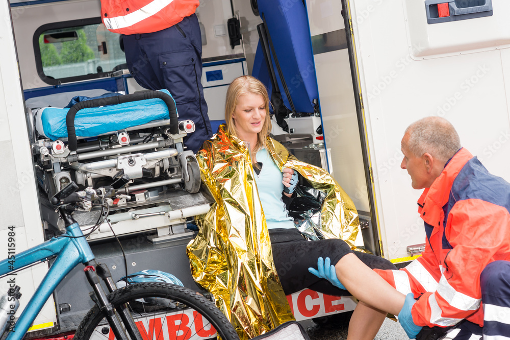 Paramedics with woman bike accident in ambulance - obrazy, fototapety, plakaty 