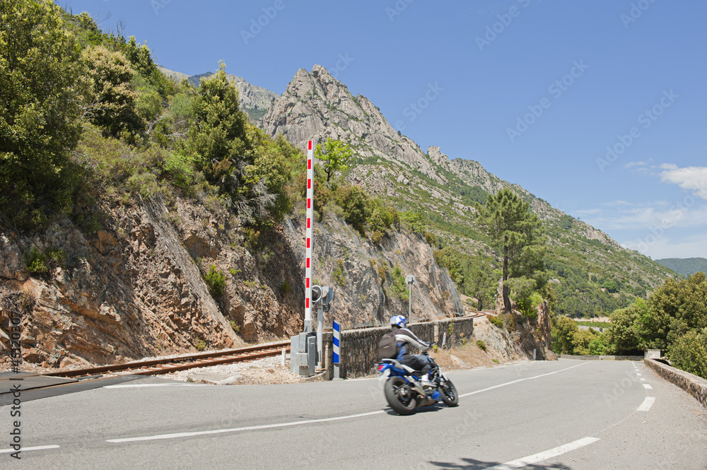 Motorcycle crossing railway track in Corsica, France