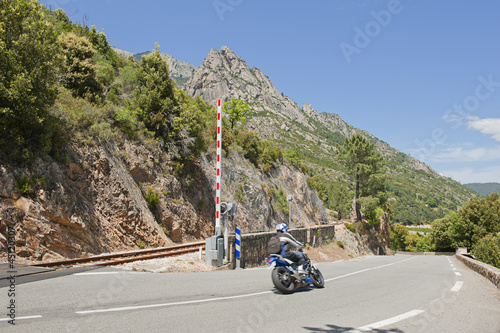 Obraz na płótnie Motorcycle crossing railway track in Corsica, France w salonie