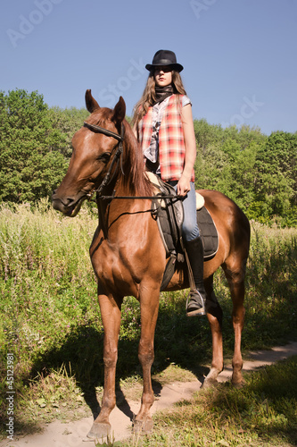 Cowgirl riding a bay horse © Demian