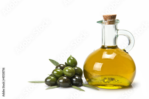 Aceitera de cristal con oliva virgen y montón de aceitunas