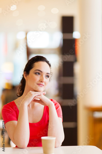 happy young woman sitting in coffee shop