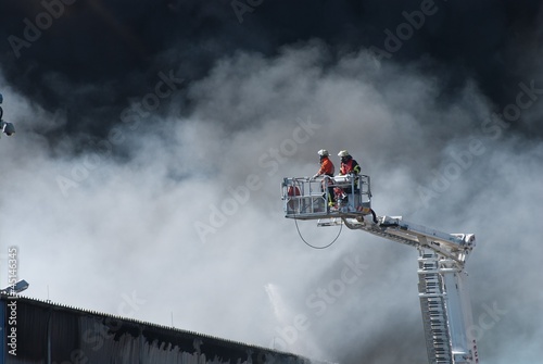 Feuerwehr auf langer Leiter im Einsatz bei Großbrand in Industriegebiet, Niedersachsen, Deutschland, Europa