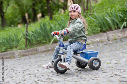 Little girl ( 4-5) on tricycle