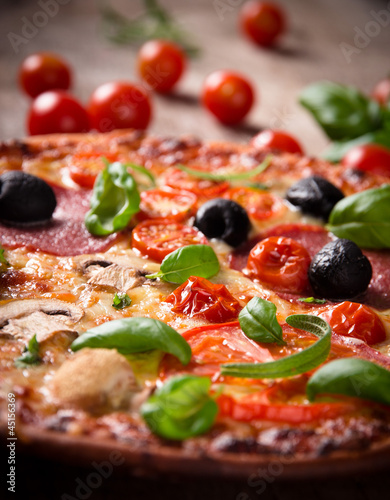 Tasty Italian pizza on wooden background