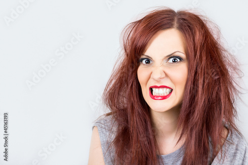 Angry unkempt redhead with red lipstick on white background