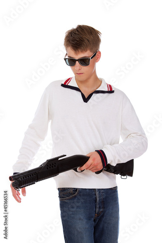 Portrait of sleazy young man posing on white background with gun photo