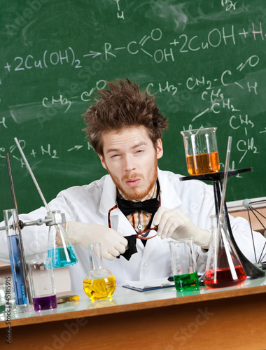 Mad professor wipes his spectacles while working in laboratory