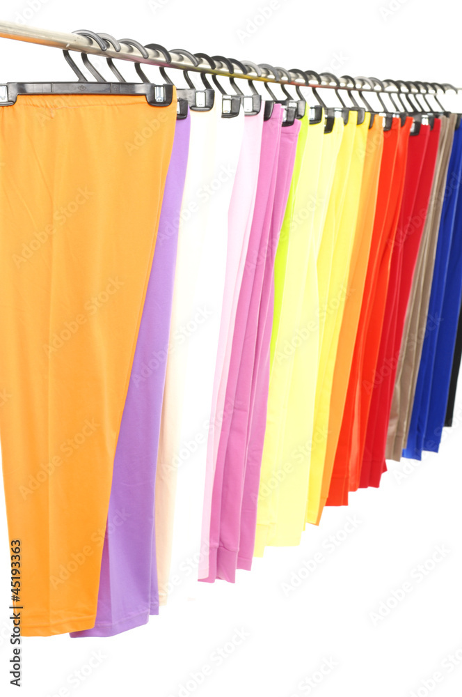 colorful female trousers on hangers