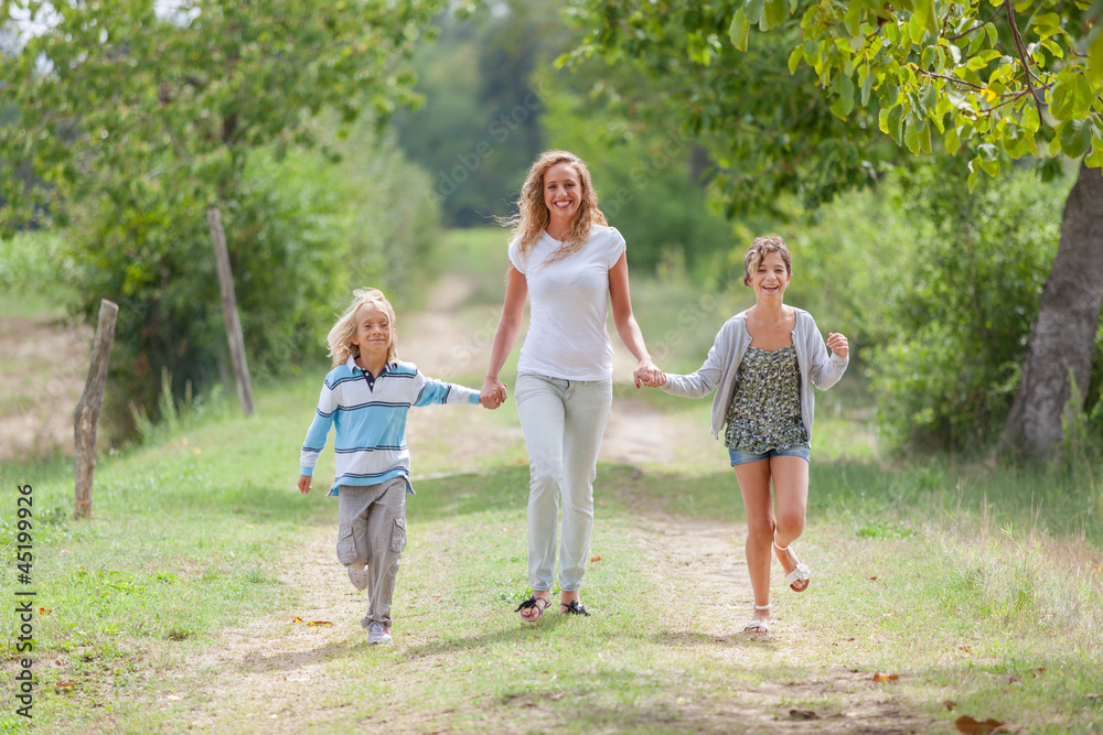 Fototapeta premium Beautiful Young Woman with Two Children Outside