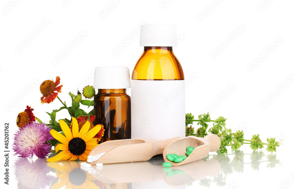 medicine bottles with tablets and flowers isolated on white